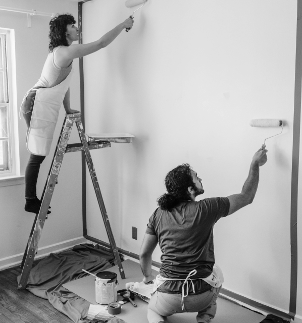 two people painting a wall